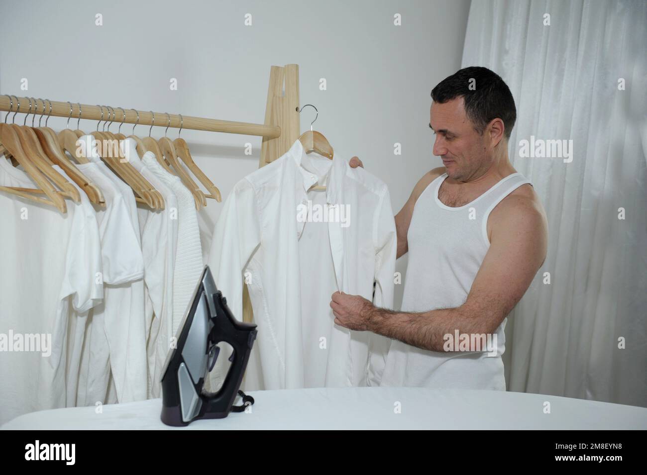 Housework and housework men ironing a shirt on an ironing board at home