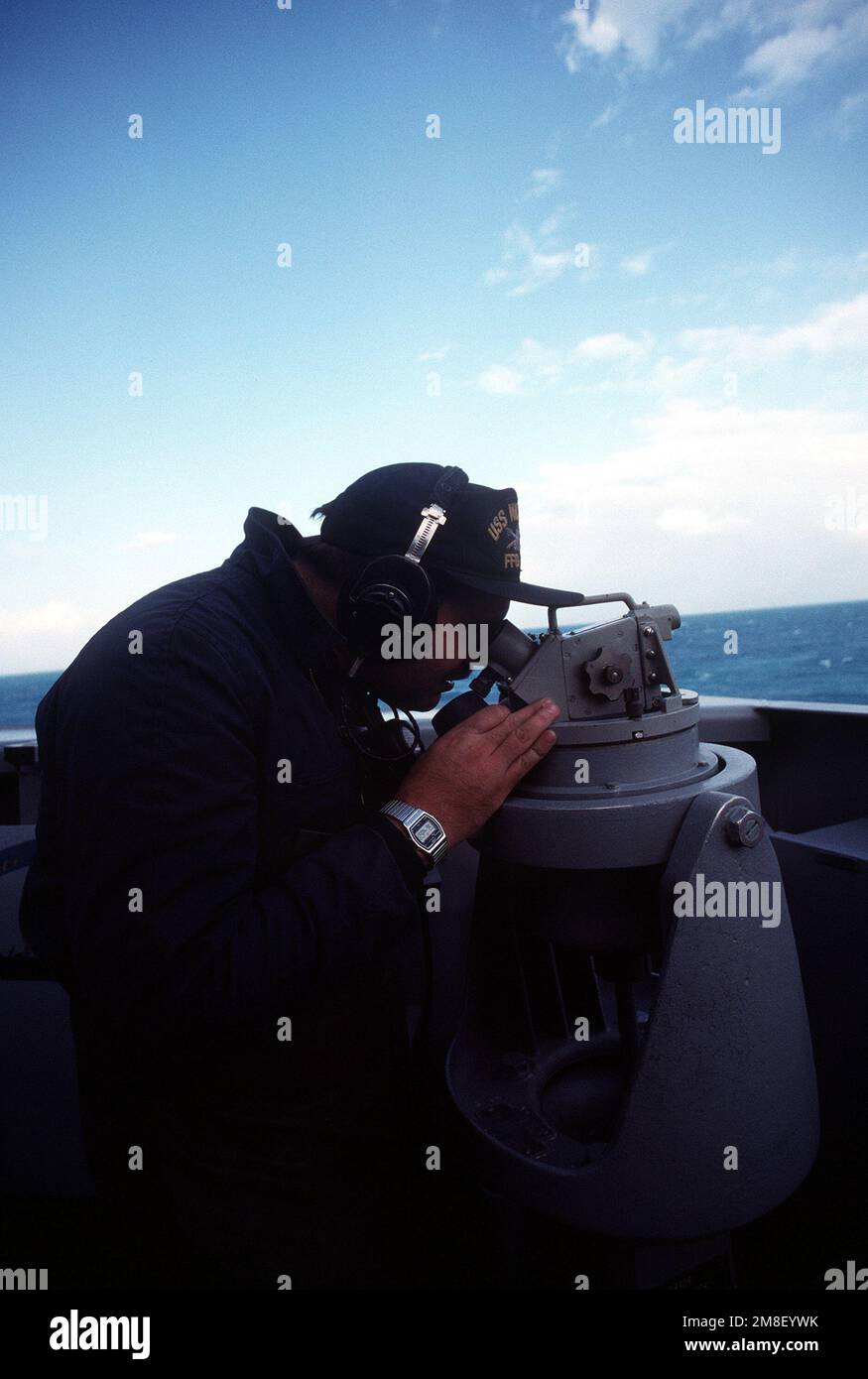 A quartermaster aboard the guided missile frigate USS NICHOLAS (FFG-47) uses a telescopic alidade to take a bearing off the coast of Bermuda as the ship returns to Naval Station, Charleston, S.C., following its deployment to the Persian Gulf region for Operation Desert Shield and Operation Desert Storm. Subject Operation/Series: DESERT SHIELD DESERT STORM Country: Atlantic Ocean (AOC) Stock Photo