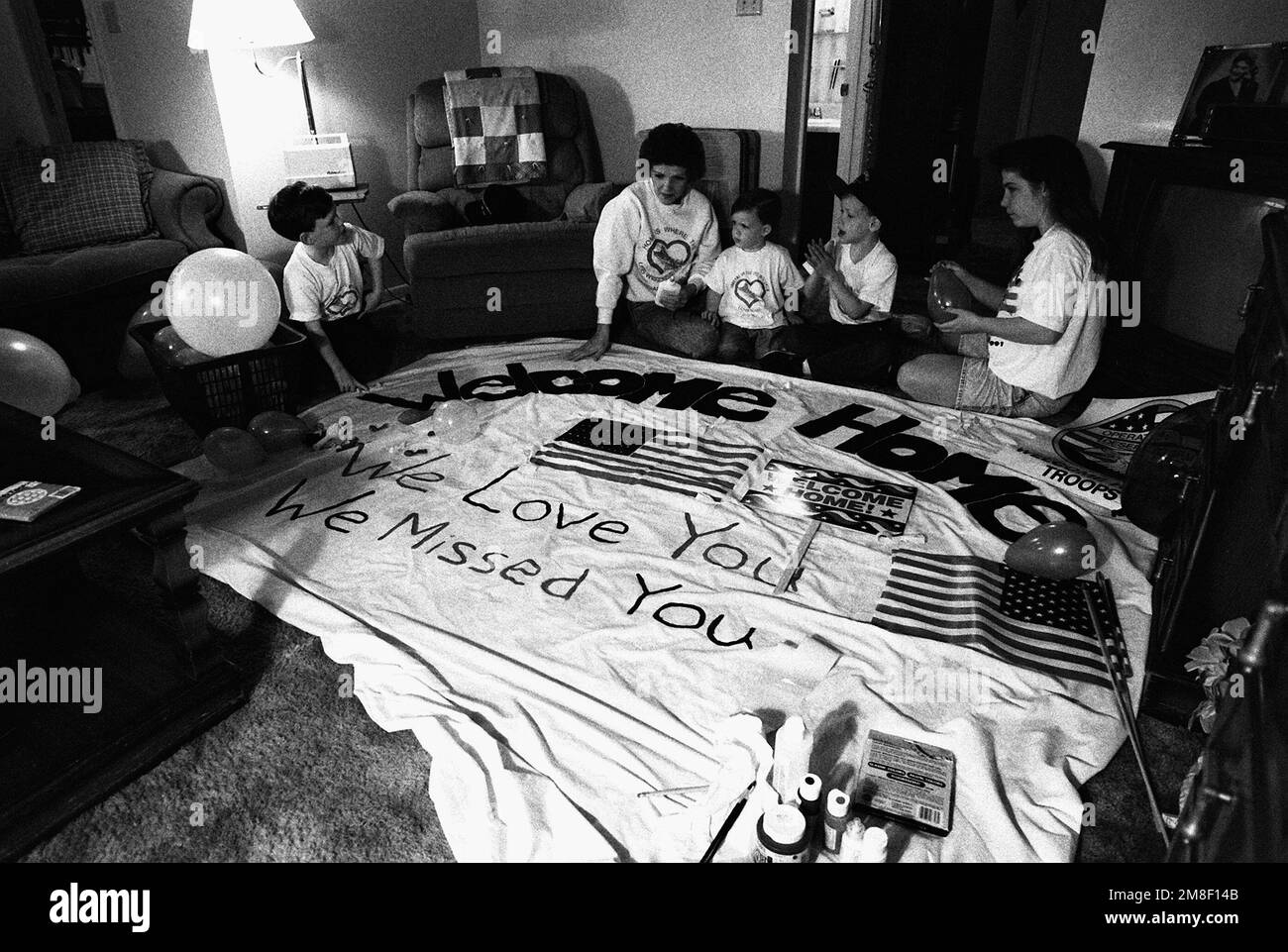 The ombudsman for the battleship USS WISCONSIN (BB-64) and her children prepare a welcome-home banner for the crew of the vessel. The WISCONSIN is scheduled to return to Naval Station, Norfolk, on March 28th following deployment in the Persian Gulf area during Operation Desert Storm. Subject Operation/Series: DESERT STORM Country: Unknown Stock Photo