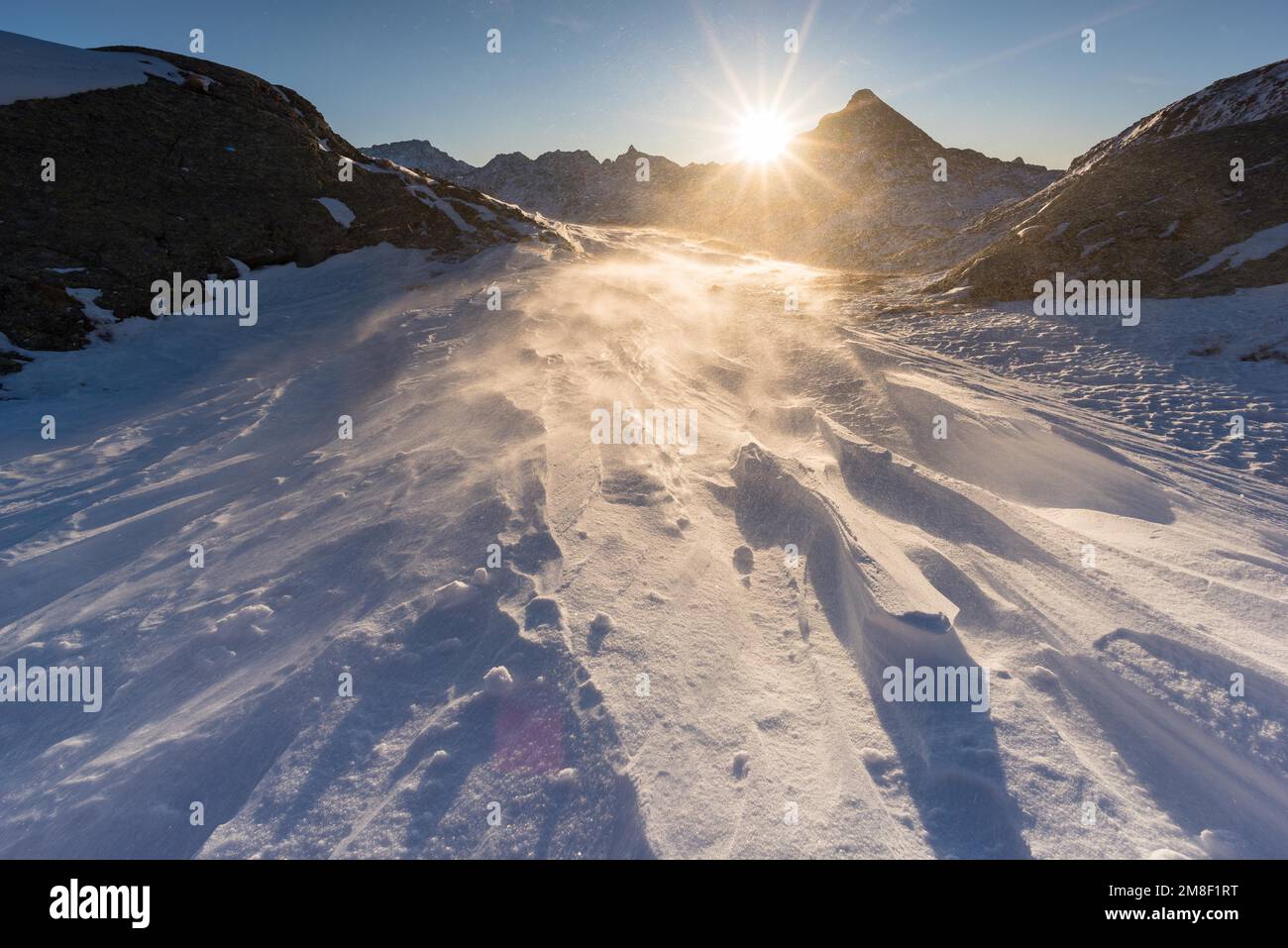 Winter landscape in the Grisons mountains with a freshening wind at sunrise, Canton Grisons, Switzerland Stock Photo