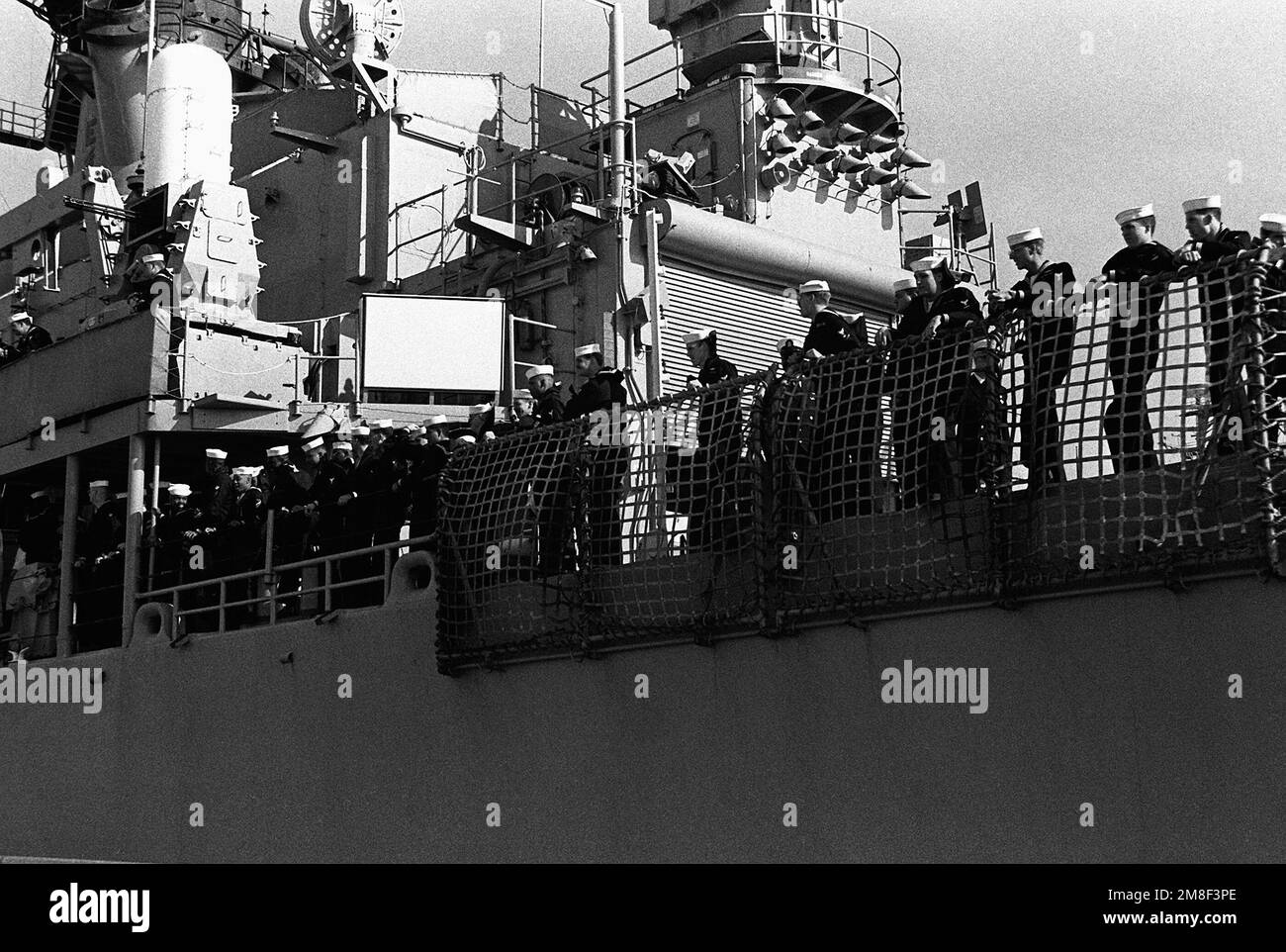 Crew members line the rail aboard the guided missile cruiser USS BIDDLE ...