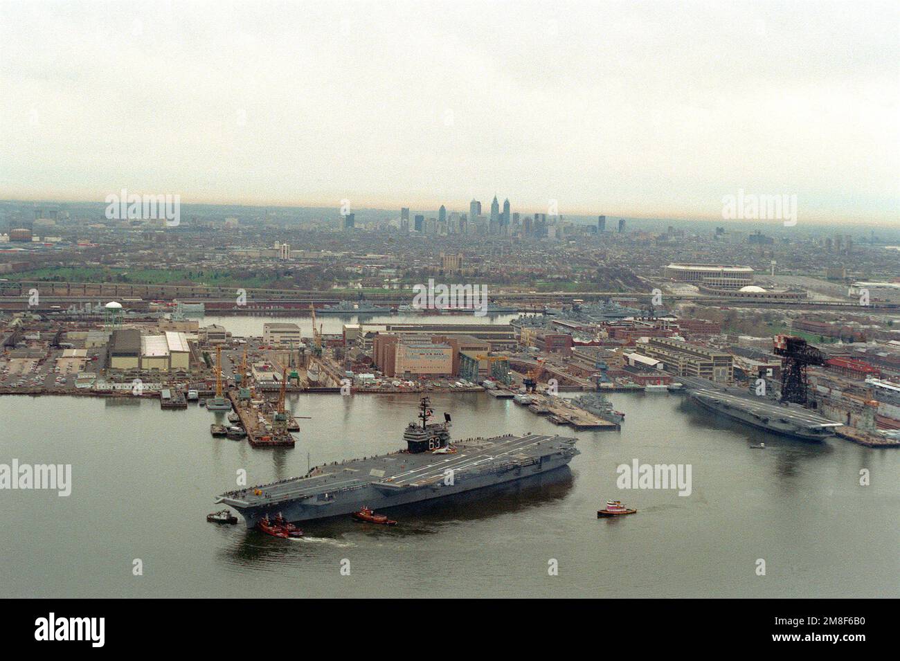 Tugs move the aircraft carrier USS KITTY HAWK (CV63) away from the