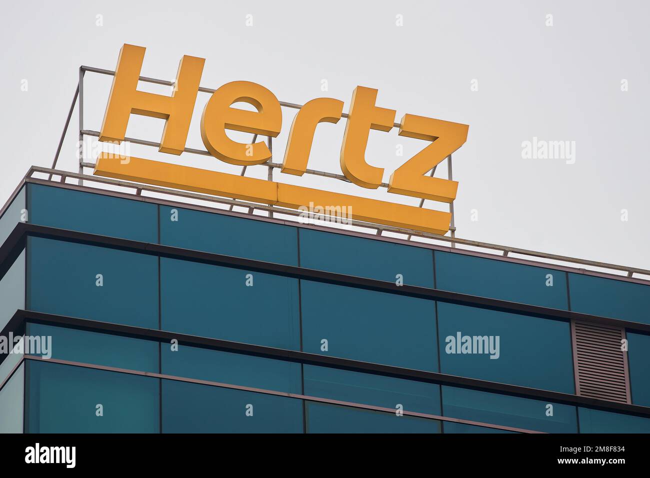Bucharest, Romania - January 13, 2023: The logo of the American car rental company Hertz can be seen on a building. This image is for editorial use on Stock Photo