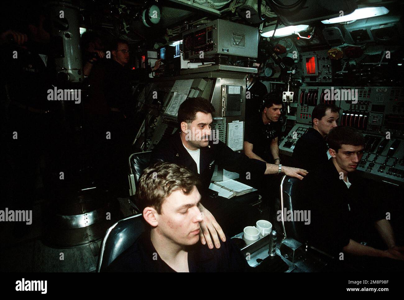 Crew members monitor equipment in the control room aboard the nuclear