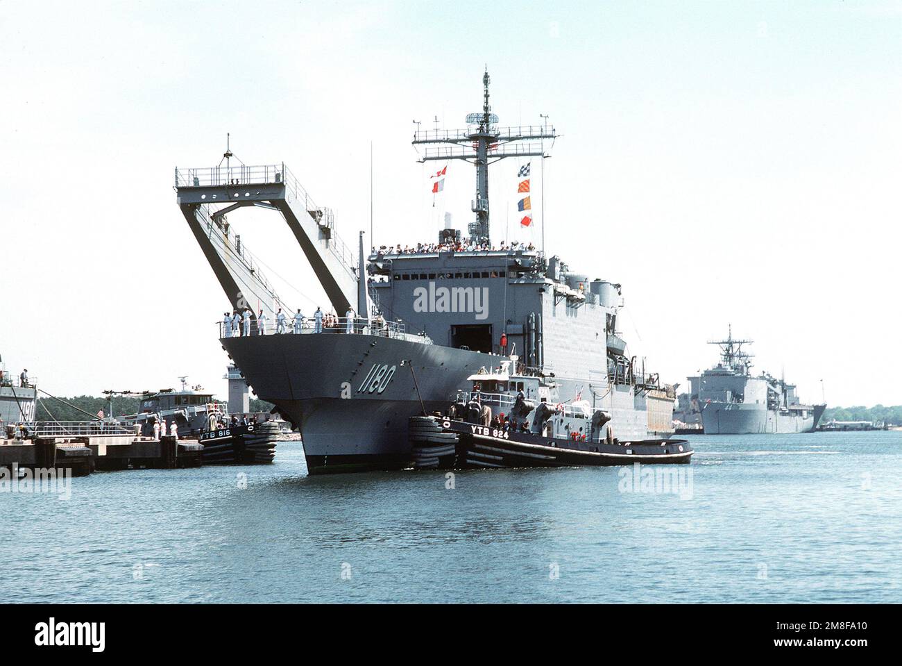The large harbor tug CAMPTI (YTB816), right, stands by as the large