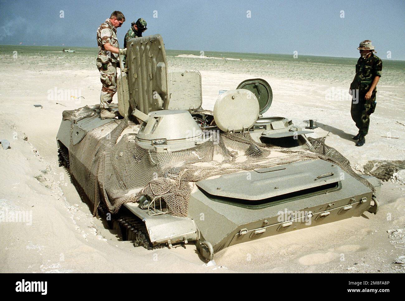U.S. soldiers inspect an Iraqi MT-LB armored personnel carrier abandoned near Ali Al Salem Air Base during Operation Desert Storm.. Subject Operation/Series: DESERT STORM Base: Ali Al Salem Air Base Country: Kuwait(KWT) Stock Photo