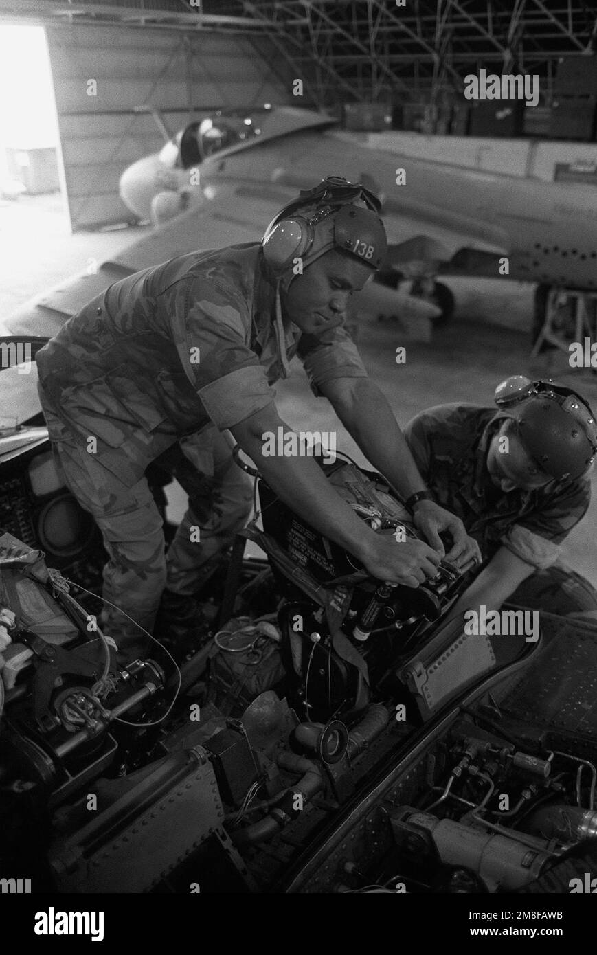 GYSGT Vince Jones and LCPL Carl A. Forester install an ejection seat in a Marine Attack Squadron 332 (VMA-332) A-6E Intruder aircraft. Base: Marine Corps Air Station,Iwakuni Country: Japan (JPN) Stock Photo