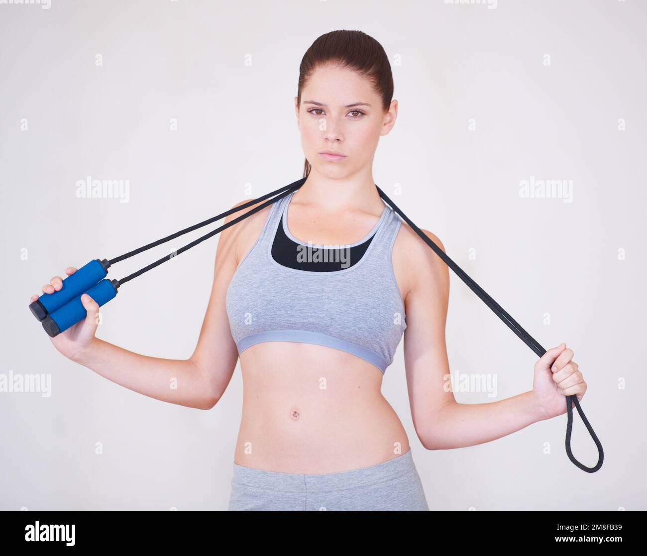Serious about skipping. Portrait of a serious-looking young woman holding a skipping rope over her shoulders. Stock Photo