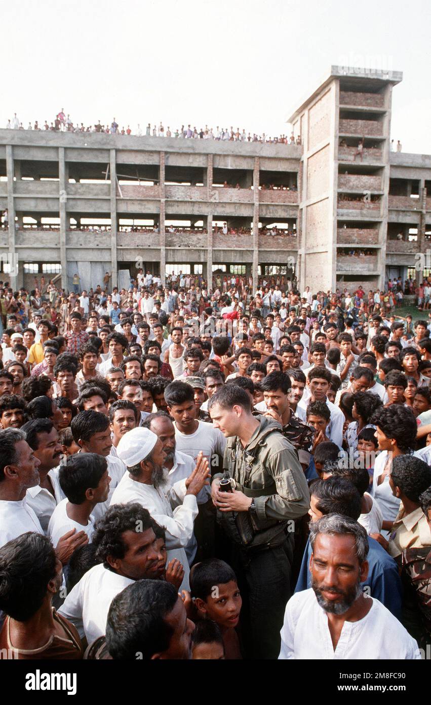 CAPT. Wayne Miller, a CH-46 Sea Knight helicopter pilot with Marine Utility/Attack Helicopter Squadron 169 (HML/A-169), speaks with local residents upon his arrival during Operation Sea Angel, a U.S. military effort to provide disaster relief to victims of a cyclone which devastated Bangladesh on April 30th.. Subject Operation/Series: SEA ANGEL Base: Haida Island Country: Bangladesh(BGD) Stock Photo