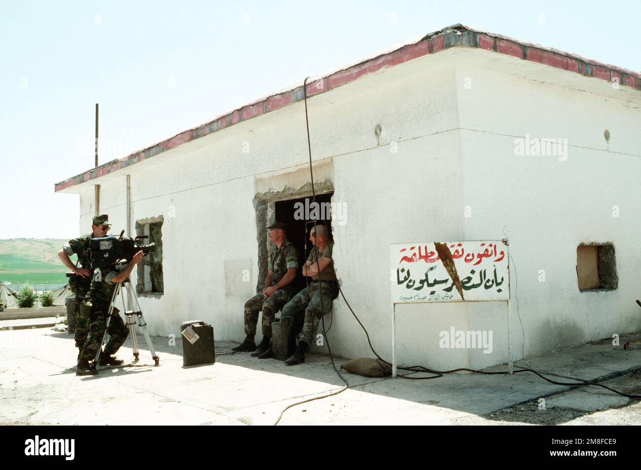 A video cameraman from the Navy Broadcasting Service sets up for an  interview beside a building on the outskirts of the city. U.S. and  coalition troops are in Zakhu as part of