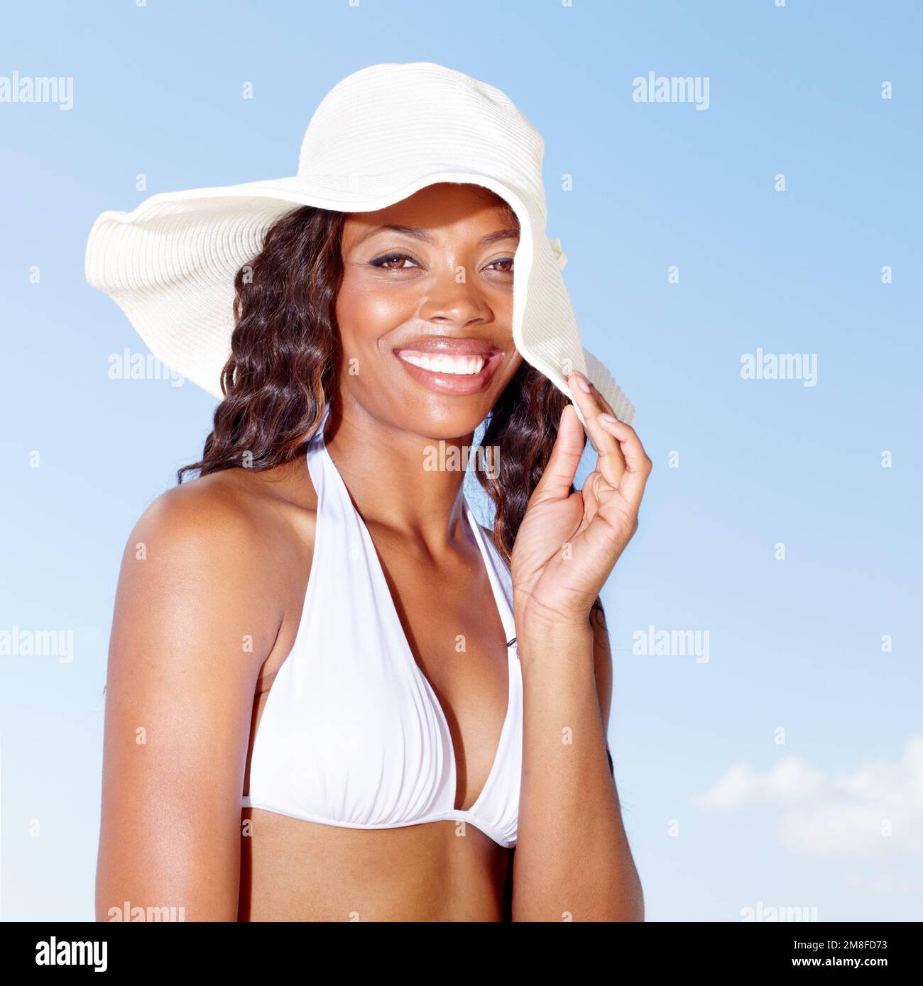 Posing in the summer sun. A beautiful young african woman enjoying the summer sun. Stock Photo