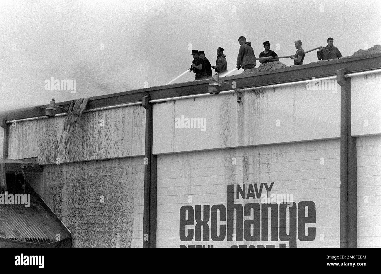 Marines wash ash off the roof of the Navy Exchange in the aftermath of