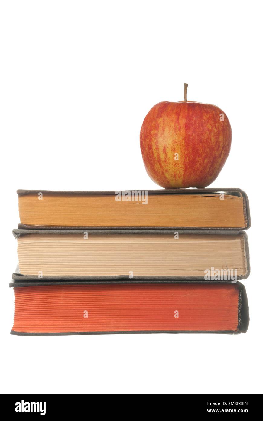 A stack of books with a red apple on white Stock Photo