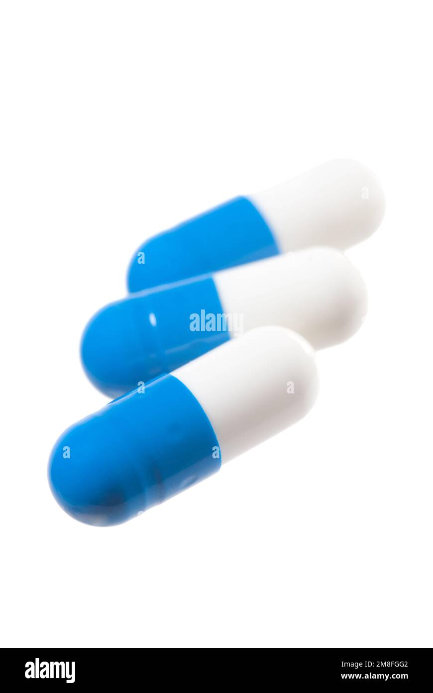 Blue pills isolated on white. Focus on the front capsule Stock Photo
