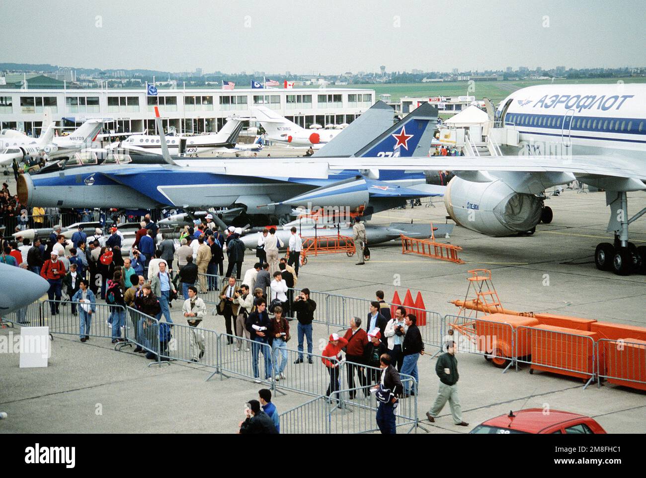 Spectators tour the displays at the 1991 Paris Air Show. In the foreground at left is a Soviet MiG-31 Foxhound aircraft; at right is a Soviet Tu-204 transport aircraft. Base: Paris Country: France(FRA) Stock Photo