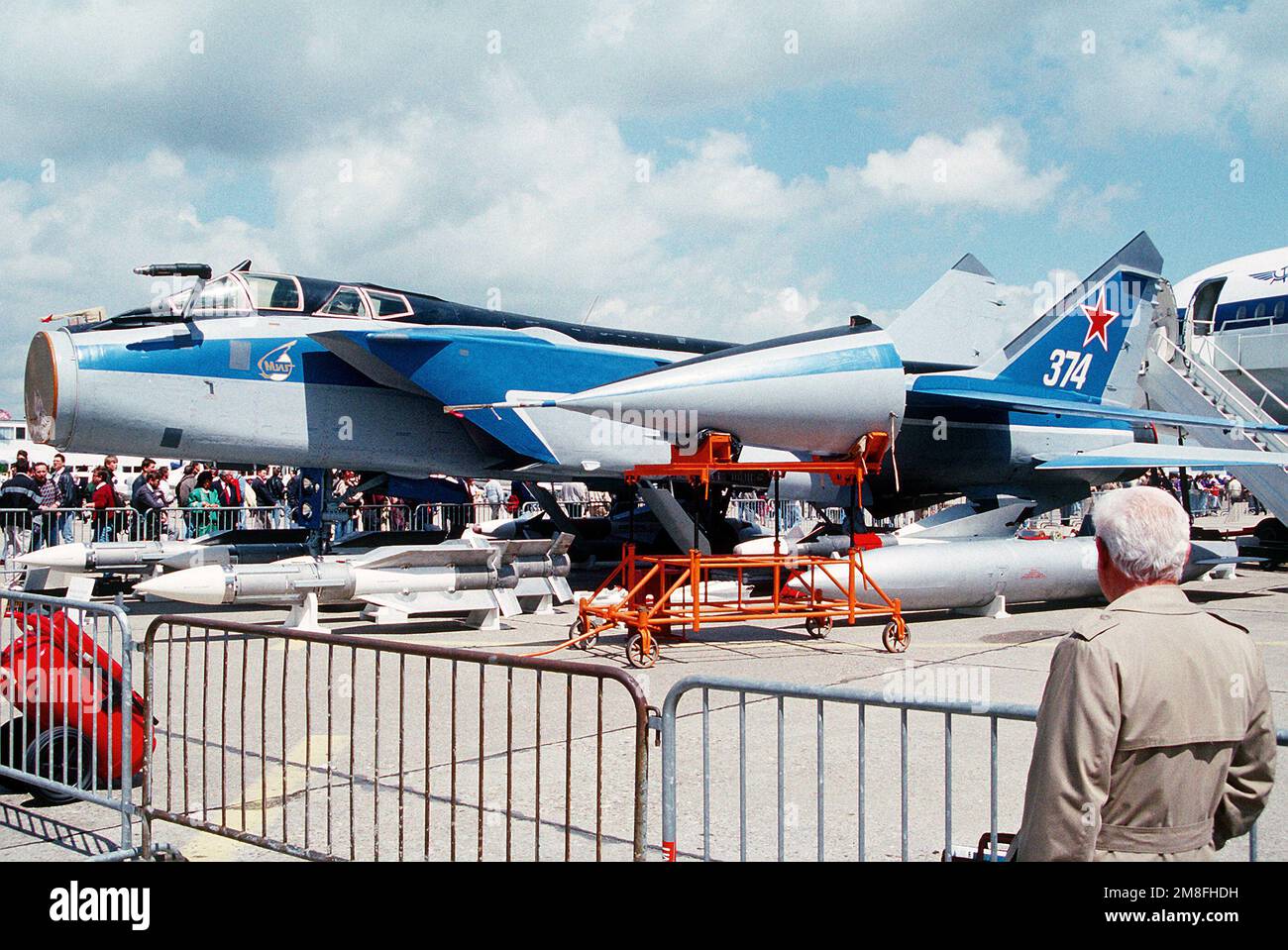 A Soviet MiG-31 Foxhound aircraft, its radome removed and on a stand at center, sits on display at the 1991 Paris Air Show. Four AA-9 Amos long-range air-to-air missiles are displayed under the front of the aircraft. Base: Paris Country: France(FRA) Stock Photo
