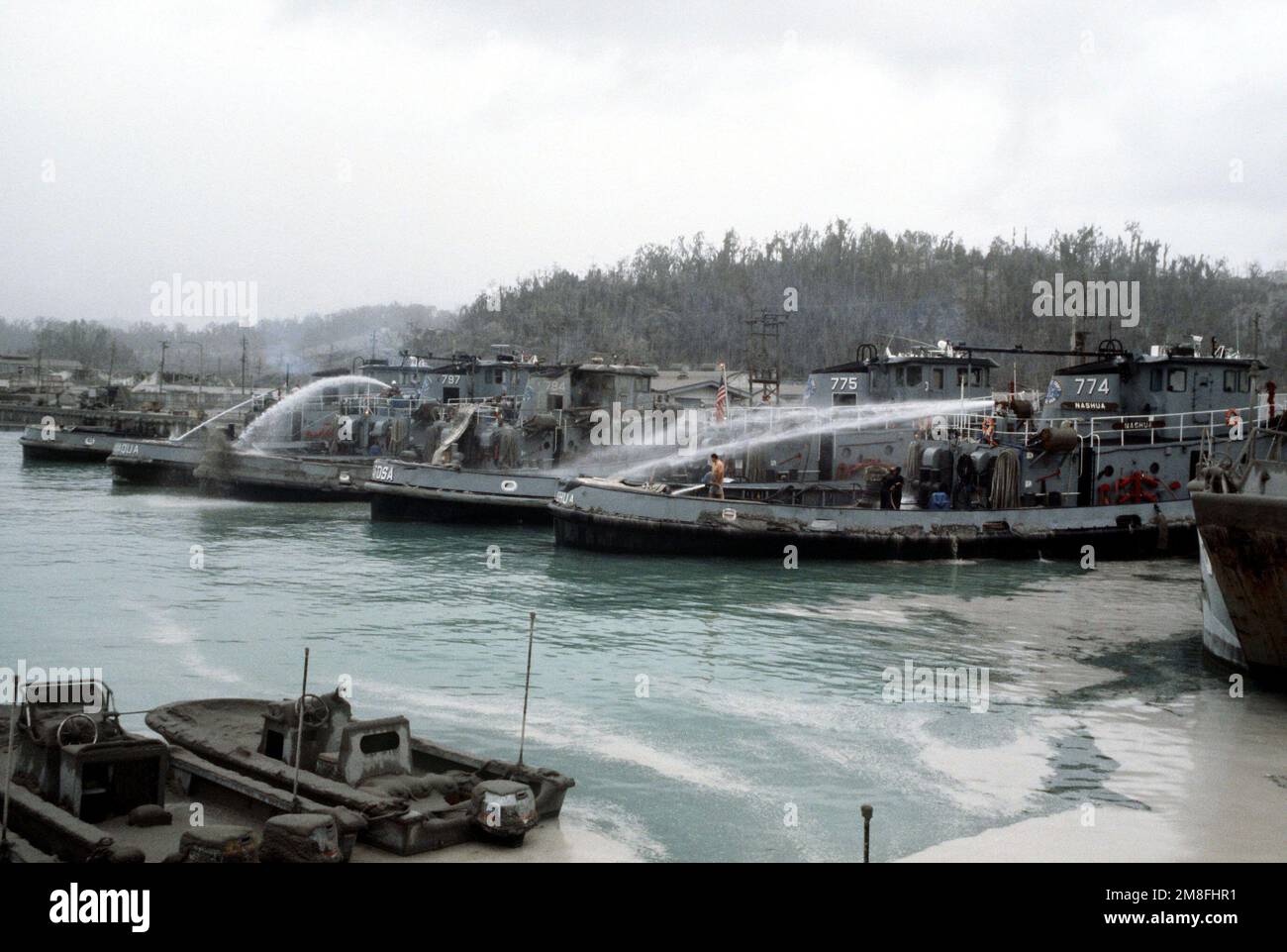 Crewmen aboard several large harbor tugs tied up at Alava Pier use