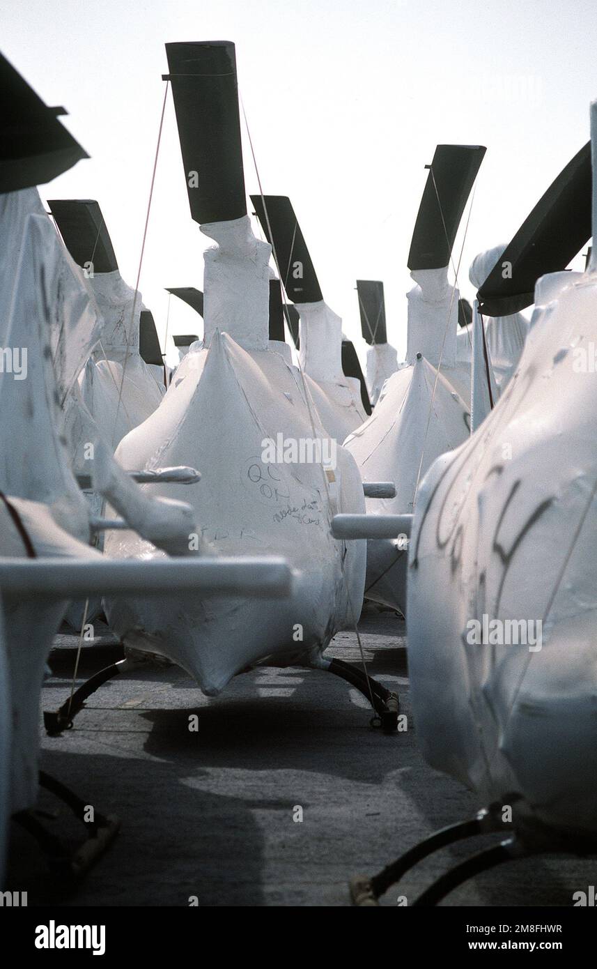 Military helicopters are wrapped for transport as they line a pier in ...