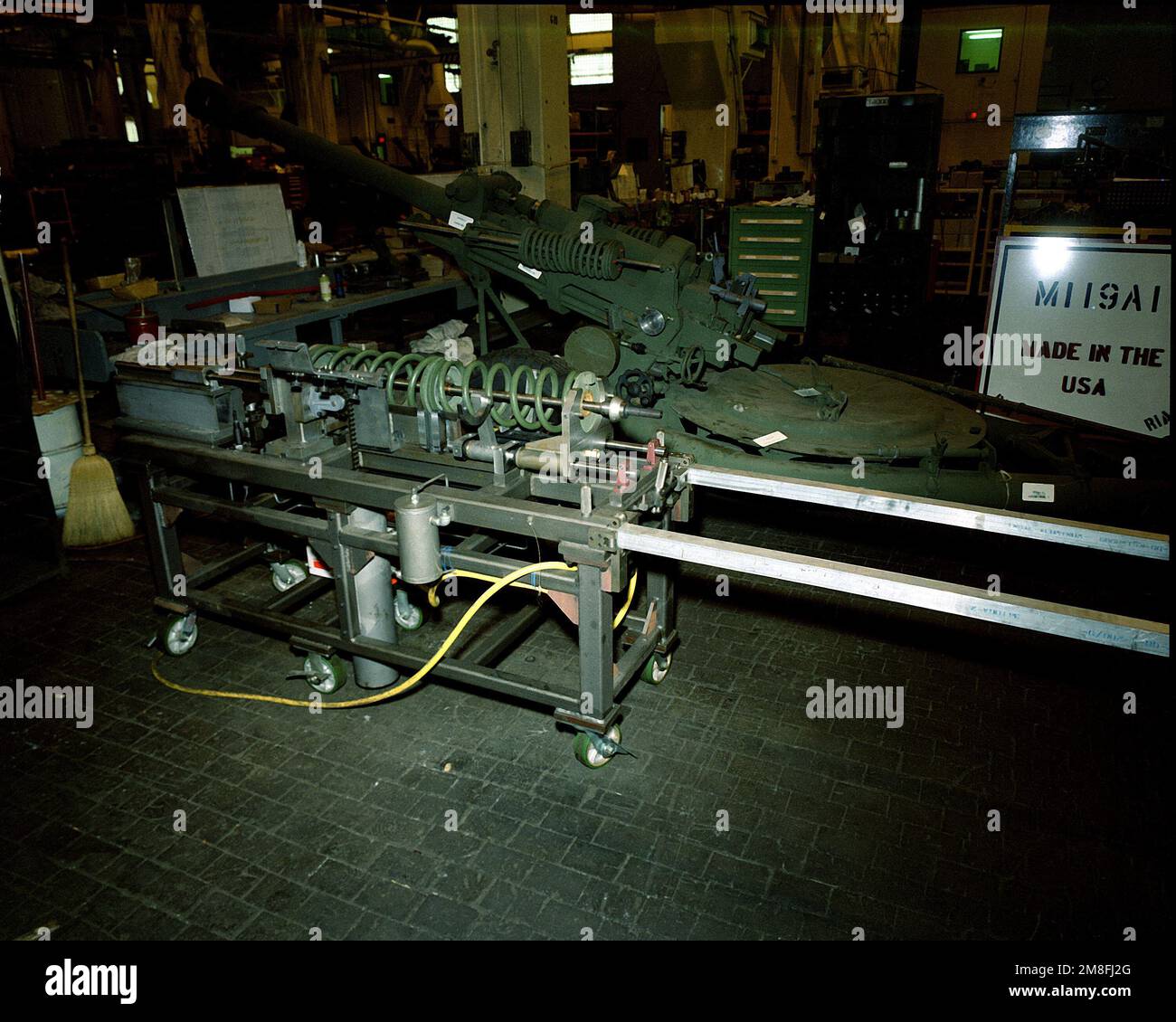 A spring compressor is used to assemble the balance gear of a 105mm M ...