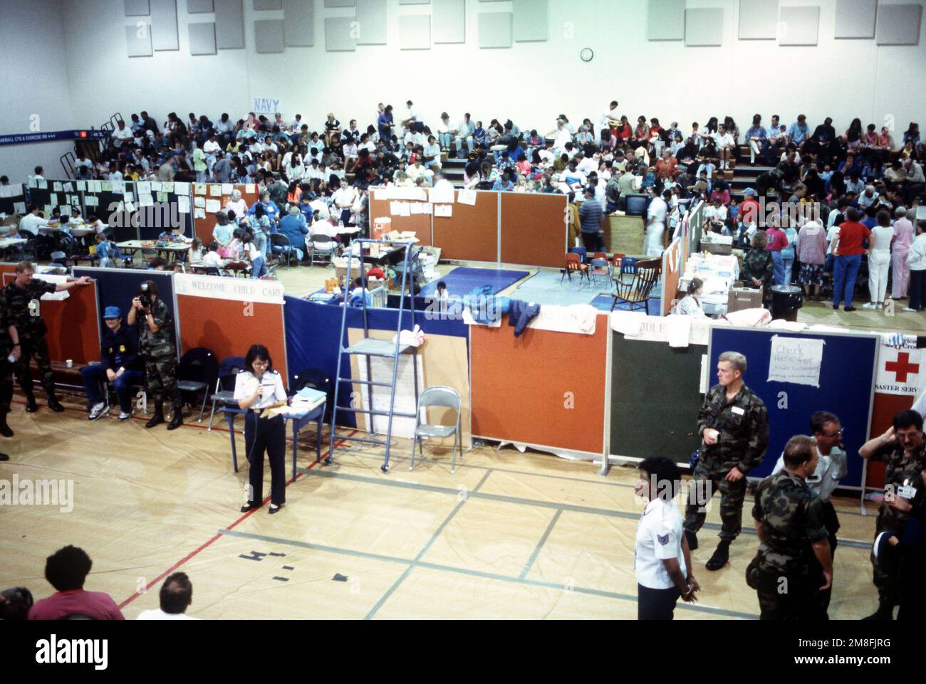 An Air Force captain speaks to dependents gathered for processing in