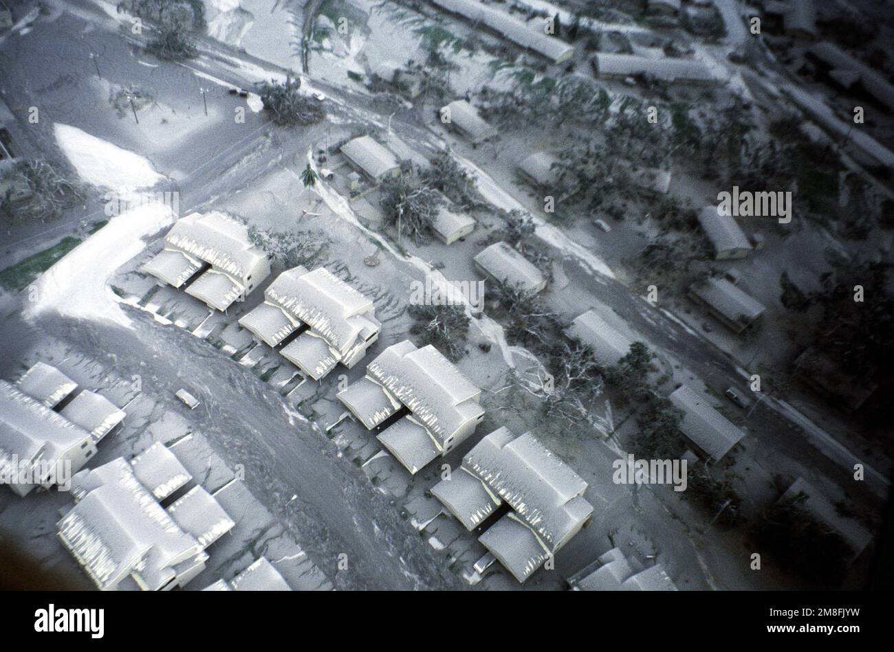An aerial view of damaged trees and ashcovered roads in the family