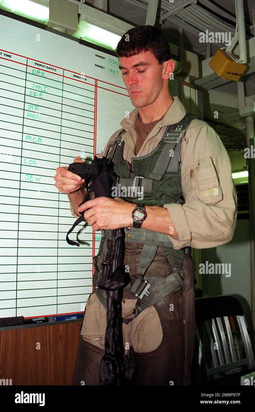 LT. Tom Steer of Fighter Squadron 114 (VF-114) arms himself with an M-9 ...