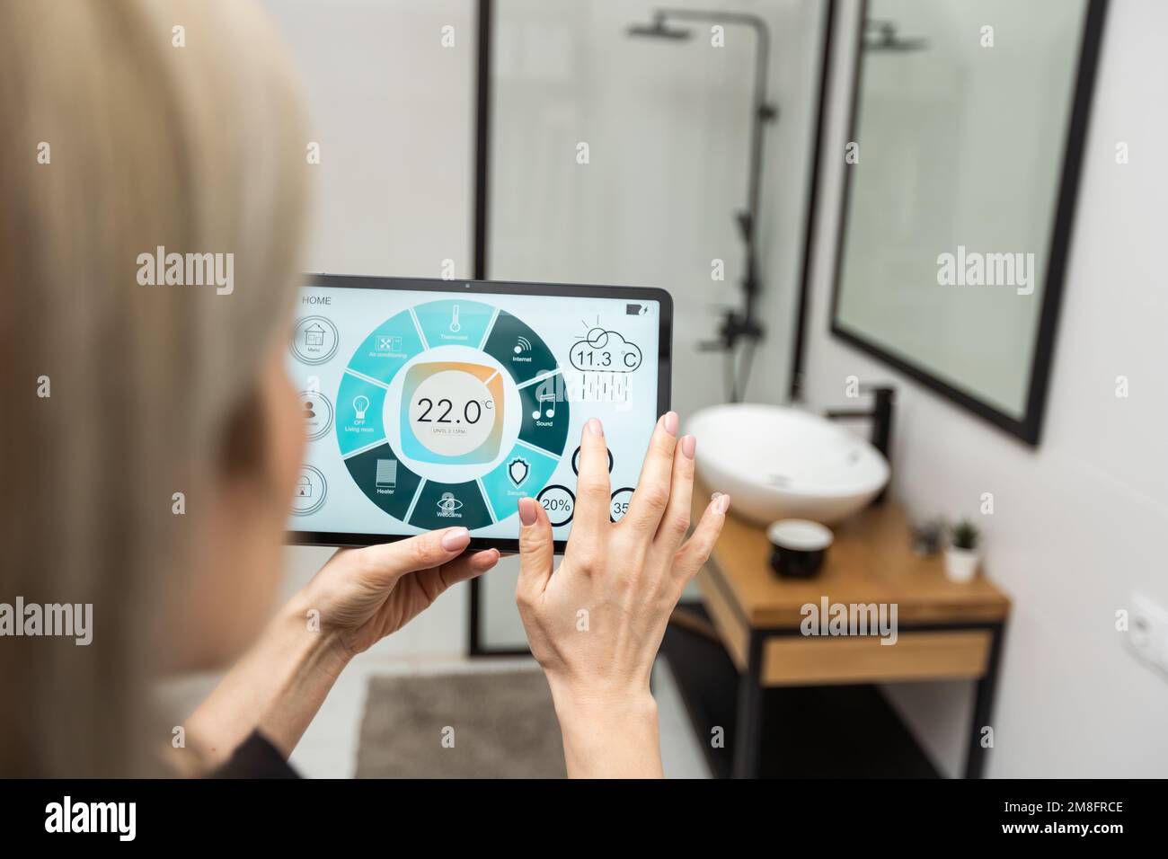 Digital composite of Hands using smart home application on tablet PC Stock Photo