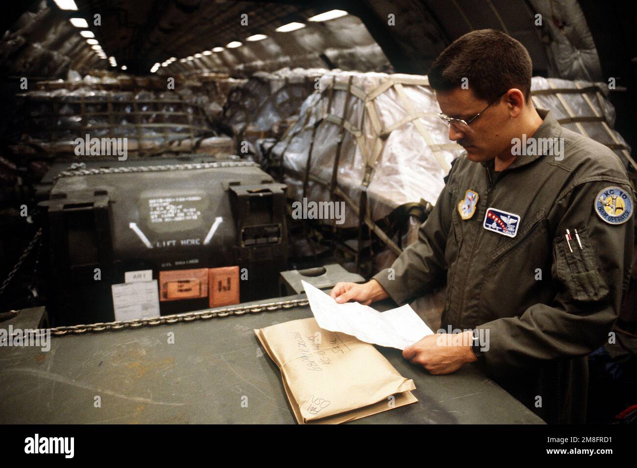 Larry Hudnut reviews the cargo load plan of a 6th Air Refueling Squadron, 22nd Air Refueling Wing, KC-10A Extender aircraft during a MIlitary Airlift Command channel cargo mission. Country: Unknown Stock Photo