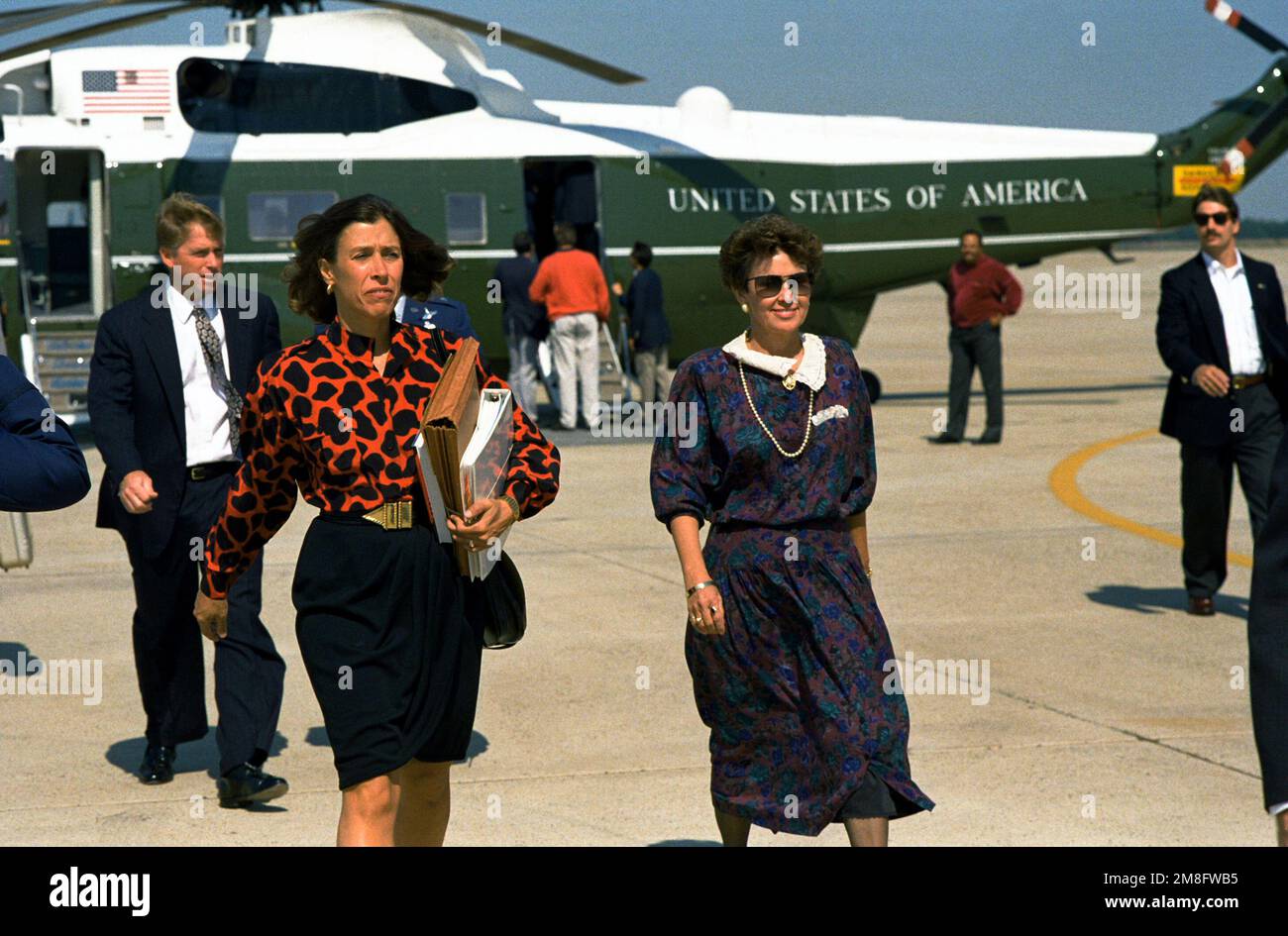Mrs. Bobbie Mitchell, wife of BGEN Bobbie L. Mitchell, commander, 89th Airlift Wing, Military Airlift Command, escorts Marilyn Quayle across the flight line as Vice President Dan Quayle, background, walks with BGEN Mitchell. The Quayles have just disembarked a VH-3D Sea King helicopter of Marine Helicopter Squadron 1 (HMX-1) and will be boarding Air Force 2 as they depart from Andrews AFB. Base: Andrews Air Force Base State: Maryland(MD) Country: United States Of America(USA) Stock Photo