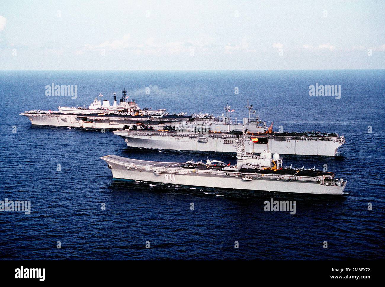 A View Of Four Ships Of The Battle Group Gathered For The Nato Exercise  Display Determination '91. The Ships Are, From Foreground To Background:  The Spanish Aircraft Carrier Principe De Asturias (R-11),