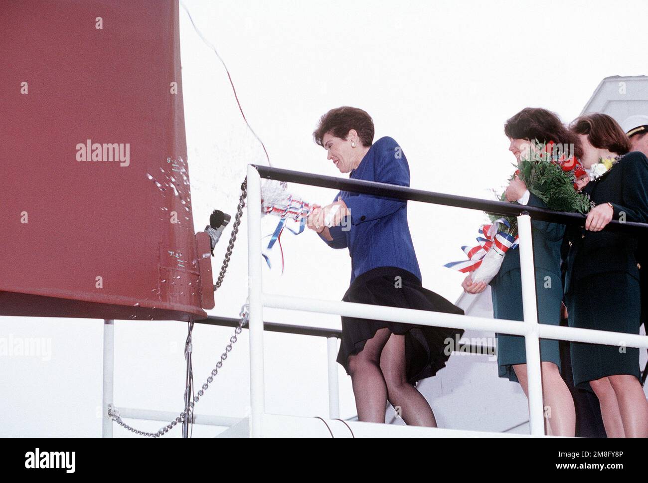 Connie Jeremiah breaks a bottle of champagne across the bow to the guided missile destroyer JOHN PAUL JONES (DDG-53) to christen the ship prior to its launch. Mrs. Jeremiah, the ship's sponsor, is the wife ADM David E. Jeremaih, vice chairman of the Joint Chiefs of STAFF. The Jeremiah's daughters Kirsta, second from right, and Jodi, right are Mrs. Jeremiah's maids of honor for the ceremony. Base: Bath State: Maine(ME) Country: United States Of America (USA) Stock Photo
