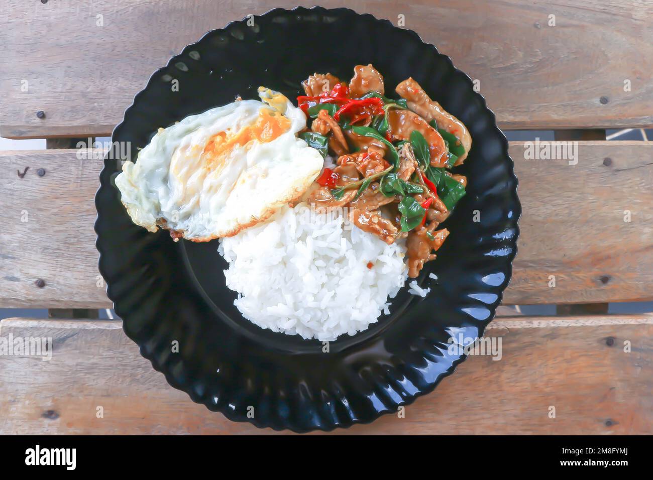 stir fried pork with chili, holy basil and rice with sunny side up egg for serve Stock Photo