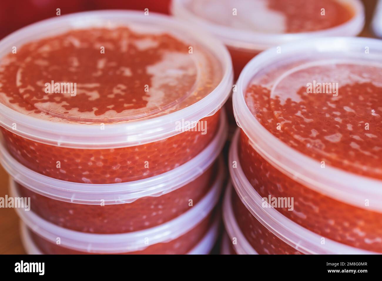 Red caviar plactic jars, rows of salted canned red caviar containers