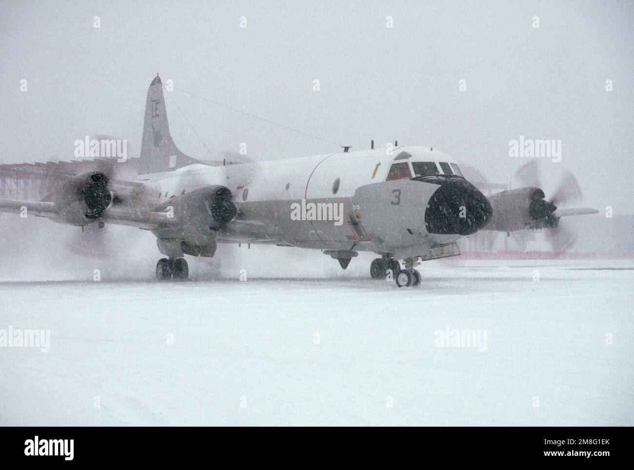 A P-3 Orion anti-submarine aircraft of Patrol Squadron 11 (VP-11) taxis into position for take-off during a New England snow storm. Base: Naval Air Station, Brunswick State: Maine(ME) Country: United States Of America (USA) Stock Photo