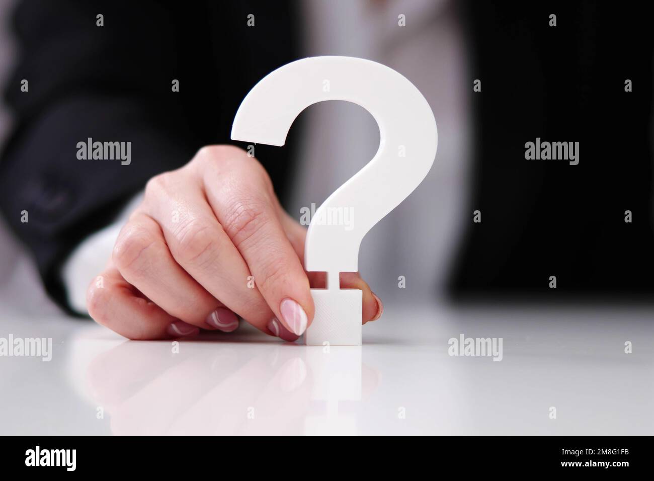 Businessperson's Hand Holding Red Question Mark Sign Stock Photo