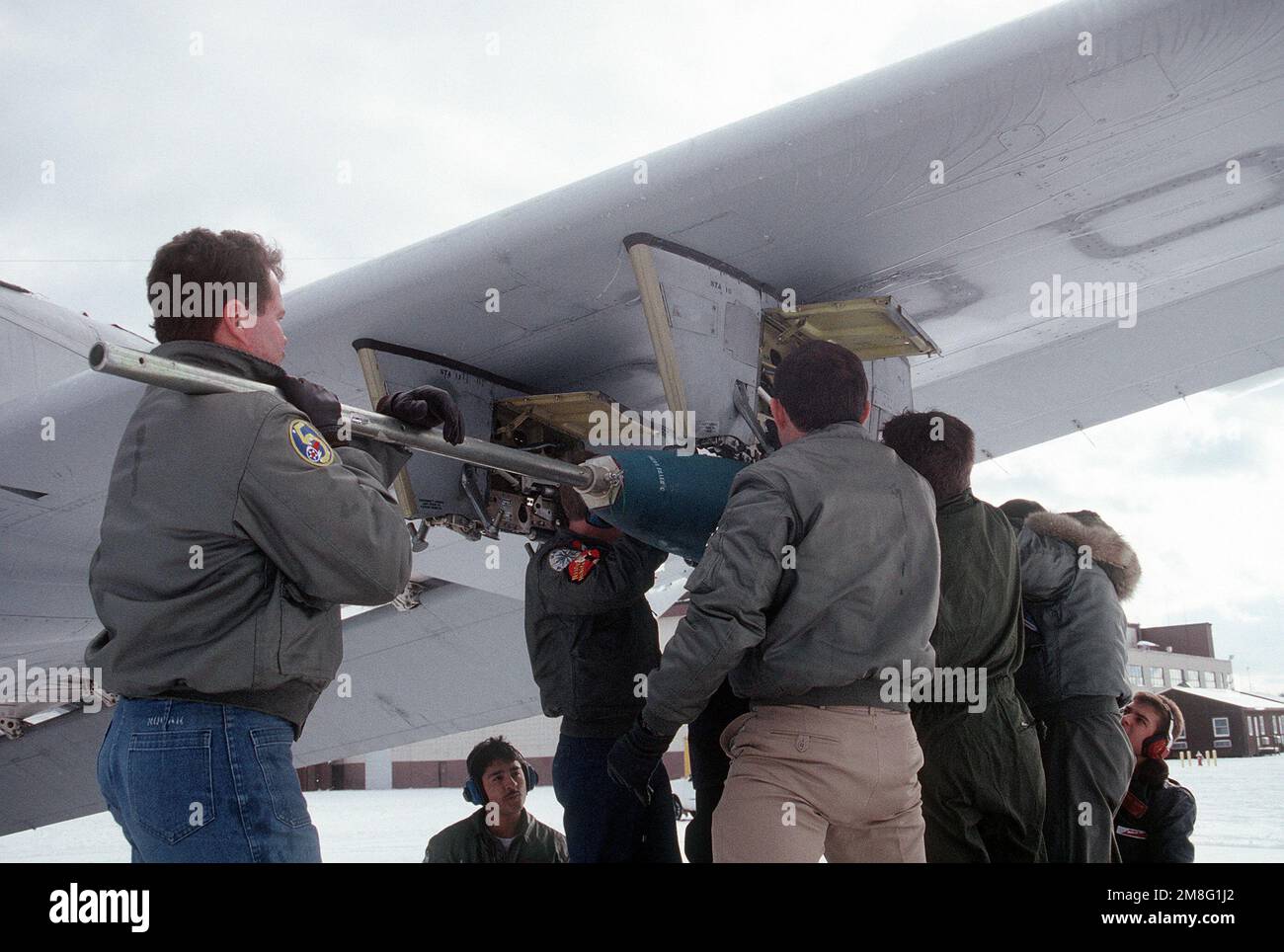 Aviation ordnancemen of Patrol Squadron 10 (VP-10) load a Mark 82 500-pound bomb beneath the wing of a P-3 Orion anti-submarine aircraft. Base: Naval Air Station, Brunswick State: Maine(ME) Country: United States Of America (USA) Stock Photo