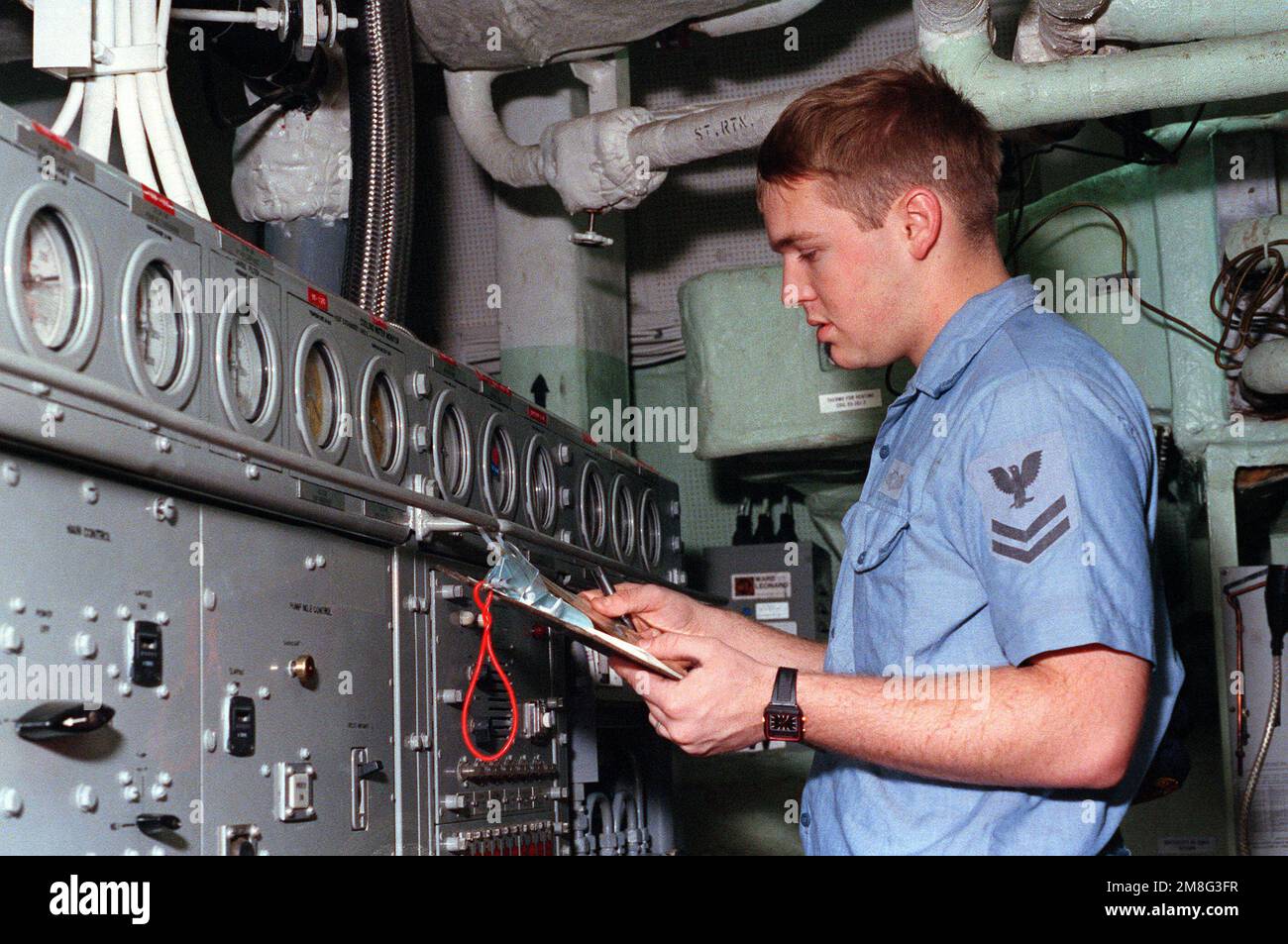 Fire Controlman 2nd Class James Klein inspects water temperature gauges ...