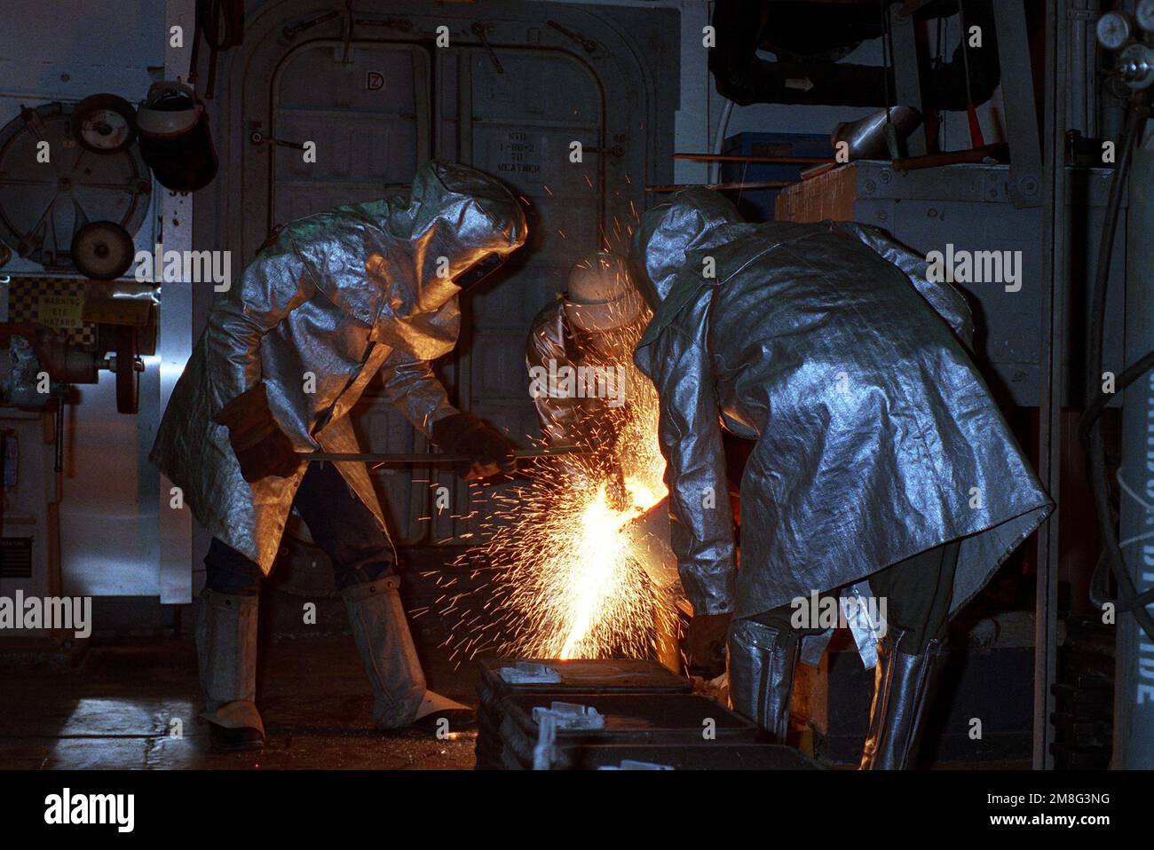 Molder 1ST Class Deem E. Ott skims slag from a pot of molten steel as ...