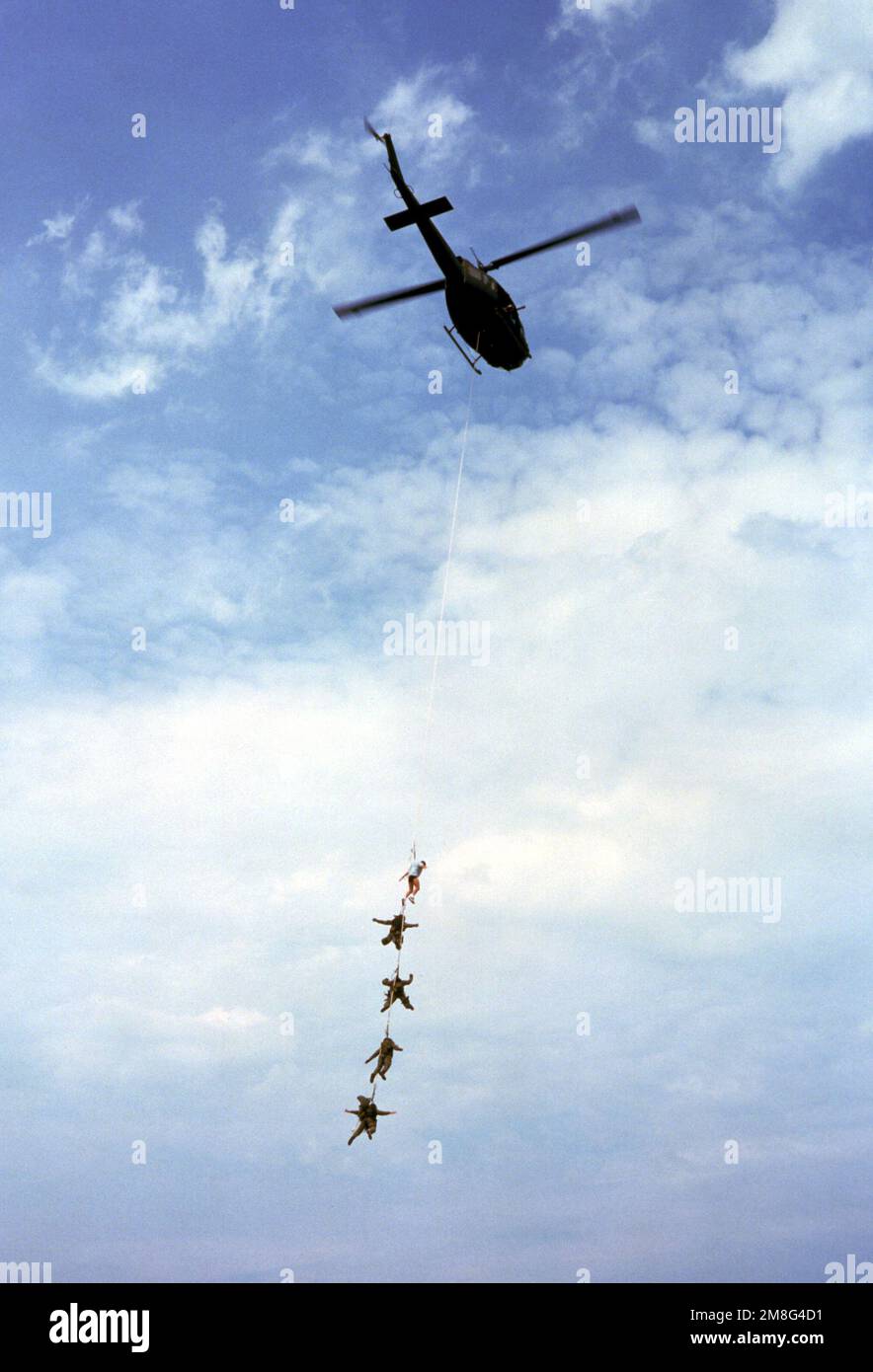 Members of Navy Sea-Air-Land (SEAL) Team 4 are suspended by Special Purpose Insertion and Extraction (SPIE) rig attached to a UH-1 Iroquois helicopter following a parachuting and beach assault demonstration. The SEALs are taking part in the 1991 Chicago Air and Water Show, which also features demonstrations by Navy fighter aircraft. Base: Chicago State: Illinois(IL) Country: United States Of America (USA) Stock Photo