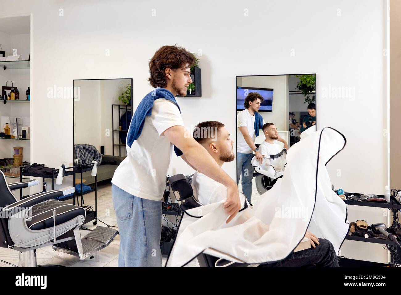 Professional barber during work with man client Stock Photo - Alamy