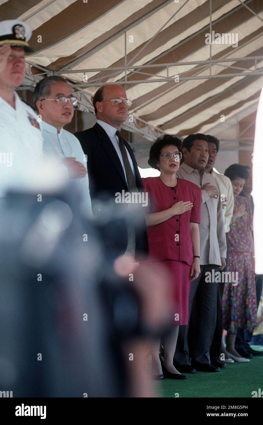 Philippine President Corazon Aquino, center, stands at attention during opening ceremonies of a rally at Remy Field. President Aquino will speak to base workers about jobs for Filipino workers after the Americans withdraw from the U.S. facilities. Base: Naval Air Station, Subic Bay Country: Philippines Stock Photo