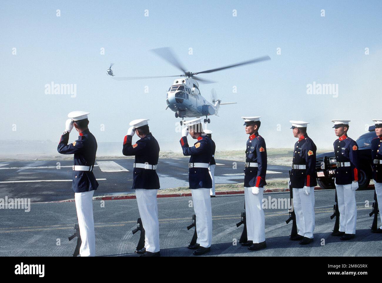 Philippine Marines, part of a joint U.S.-Philippine Marine honor guard, stand in formation as an SA-330 Puma helicopter transporting Philippine President Corazon Aquino arrives on base. Base: Naval Station, Subic Bay State: Luzon Country: Philippines(PHL) Stock Photo