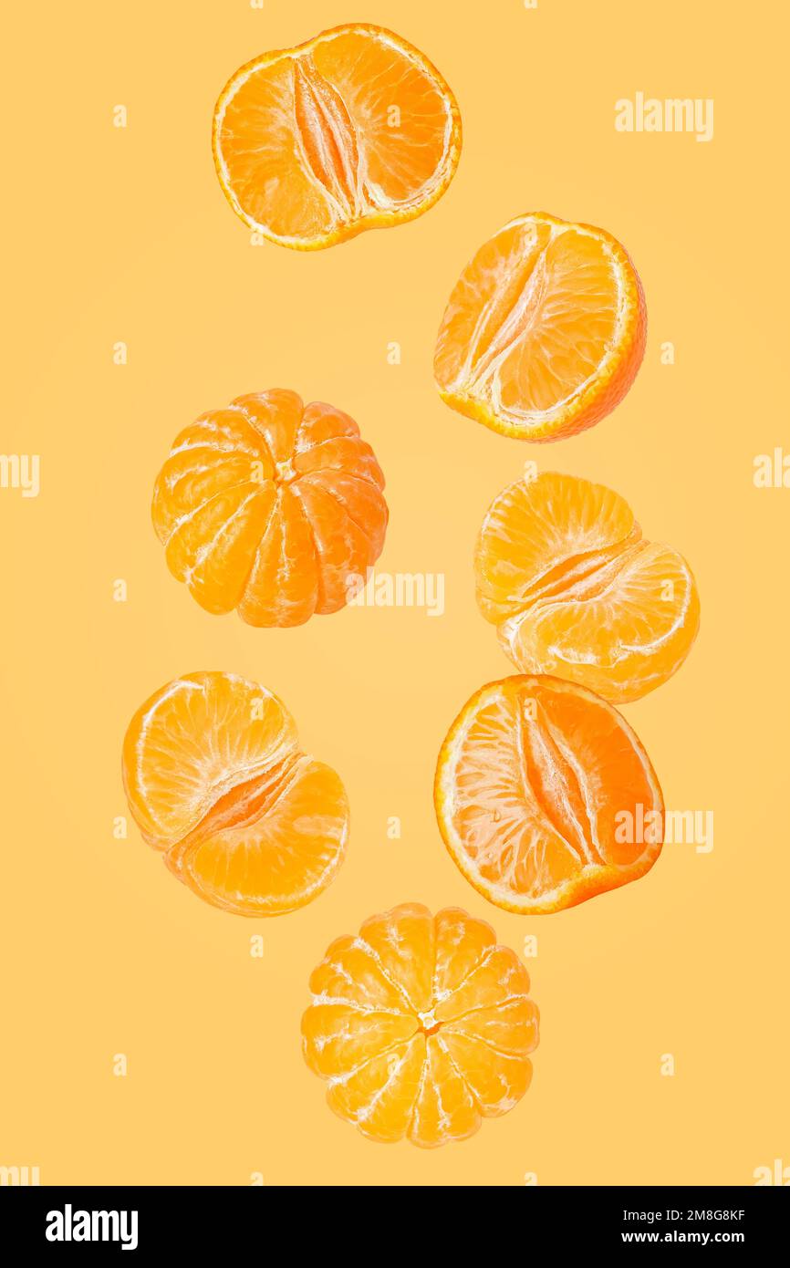 Isolated flying grapes. Seven whole and sliced mandarin fruits falling