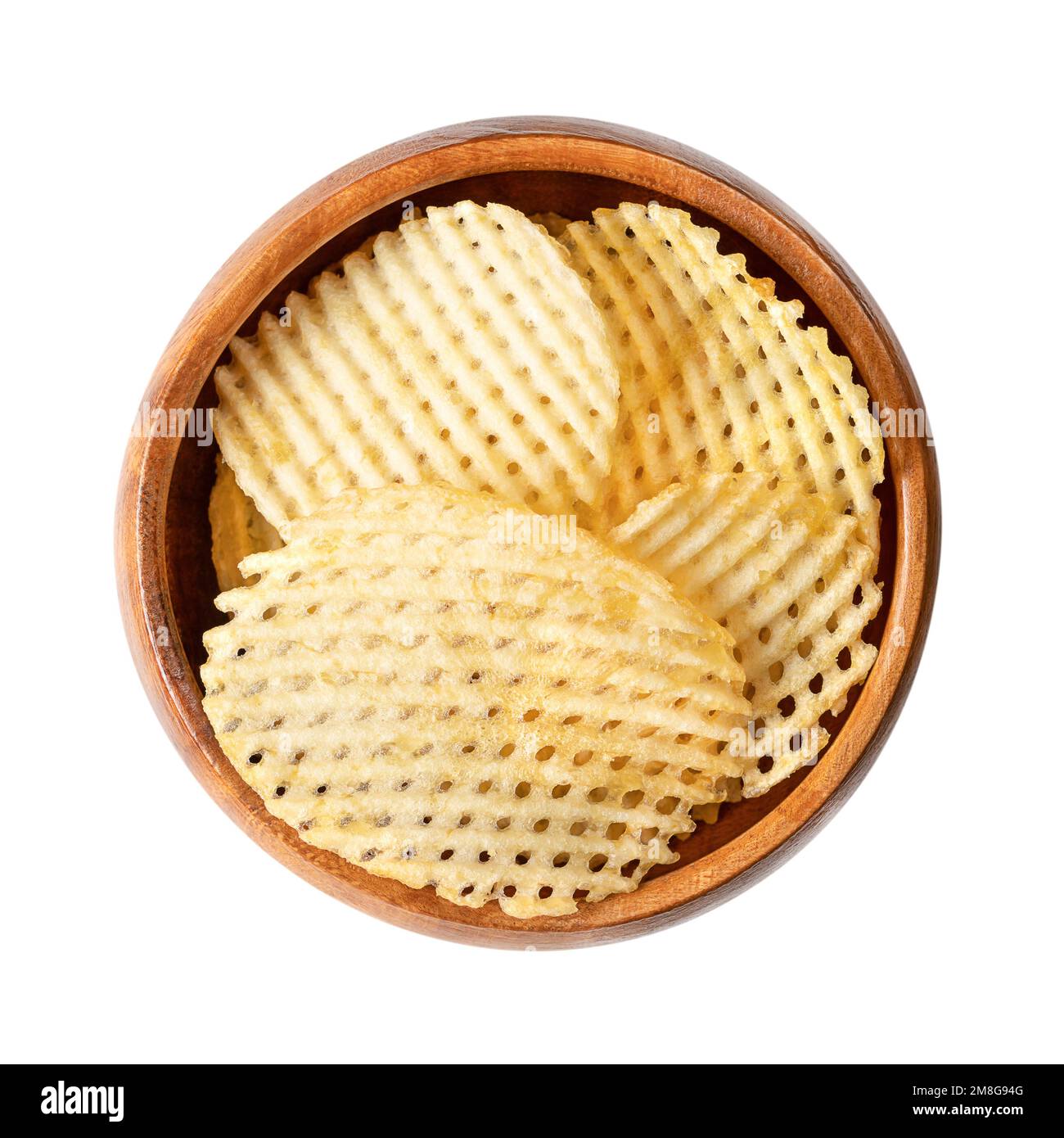 Lattice cut potato chips, in a wooden bowl. Cut crisps with grid pattern, deep fried in oil until crunchy and salted. A snack, side dish or appetizer. Stock Photo