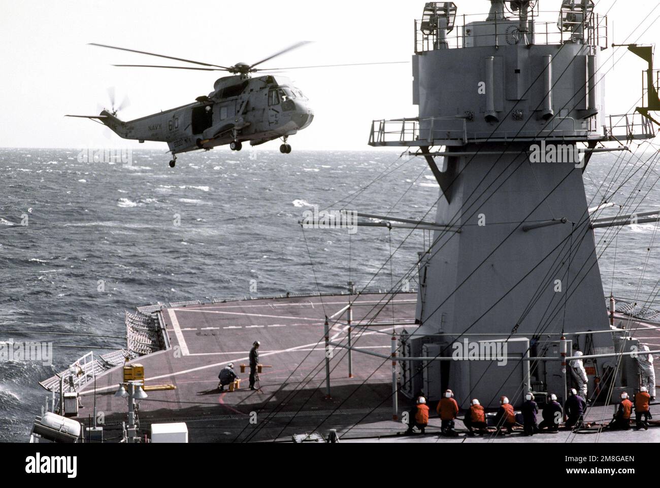 An SH-3 Sea King helicopter prepares to land aboard the amphibious command ship USS BLUE RIDGE (LCC-19) as the vessel is underway. The BLUE RIDGE is the flagship of commander, 7th Fleet. Country: South China Sea Stock Photo