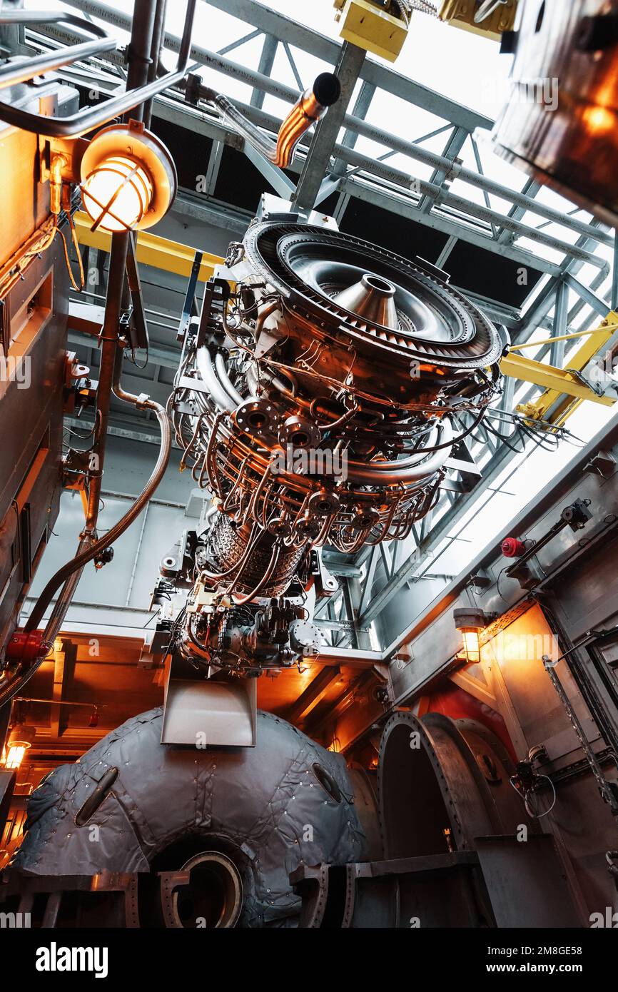 The engine of a gas turbine compressor hangs on a crane during installation in a module for generating electricity Stock Photo