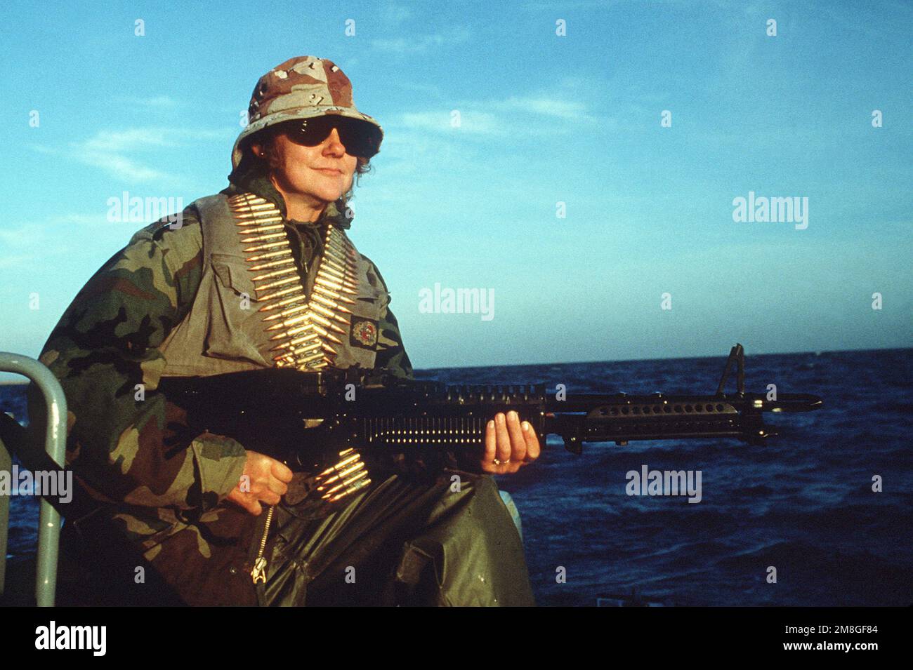 Boatswain's Mate 3rd Class Robin Eckel is armed with an M60 machine