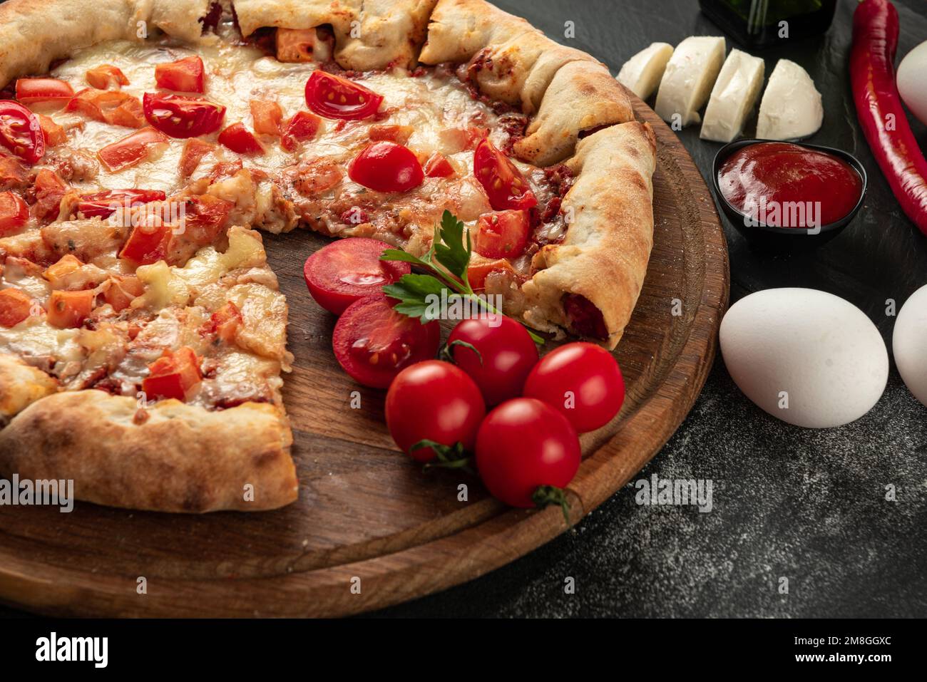 Ingredients for the pizza on a dark background. Indian pizza with tomatoes and peppers close up