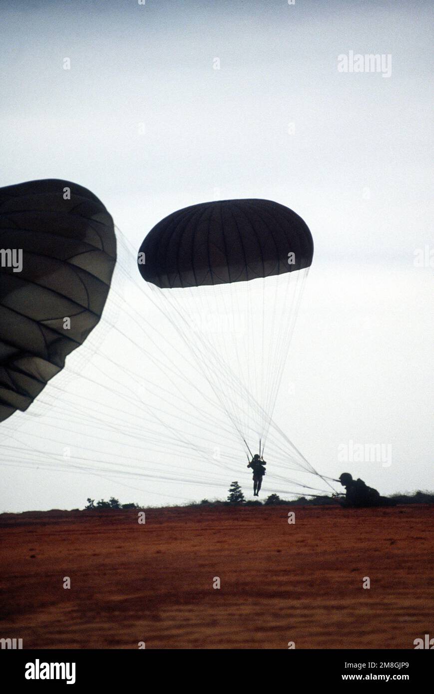 U. S. Army paratroopers landing on a Fort Bragg drop zone, competing in ...