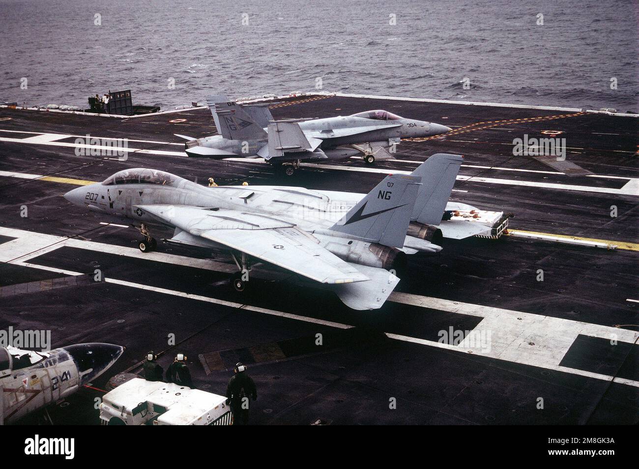 A Fighter Squadron 24 (VF24) F14A Tomcat aircraft stands by as an F/A